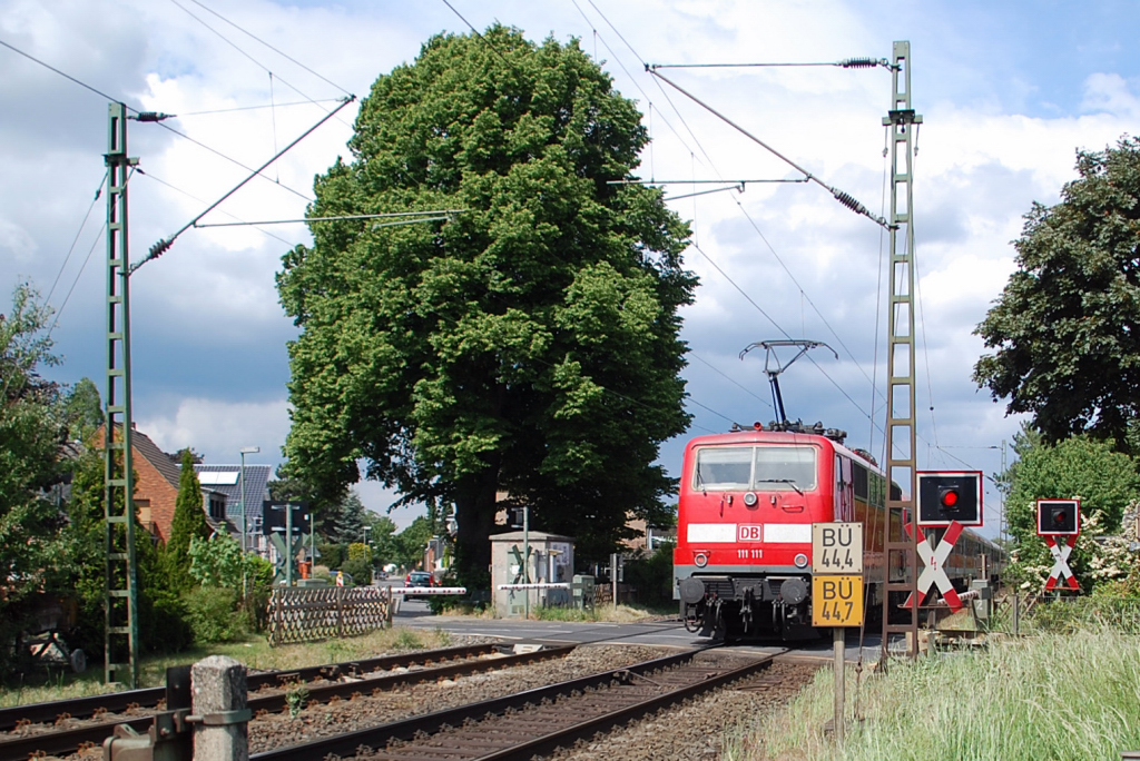 Bahnbergang Goerschkesheideweg in Osterath am Kilometer 44,4. Gerade ist die 111 111-1 mit einem N-Wagenzug in Richtung Krefeld unterwegs. Aufgenommen am Sonntag den 15.Mai 2011.
