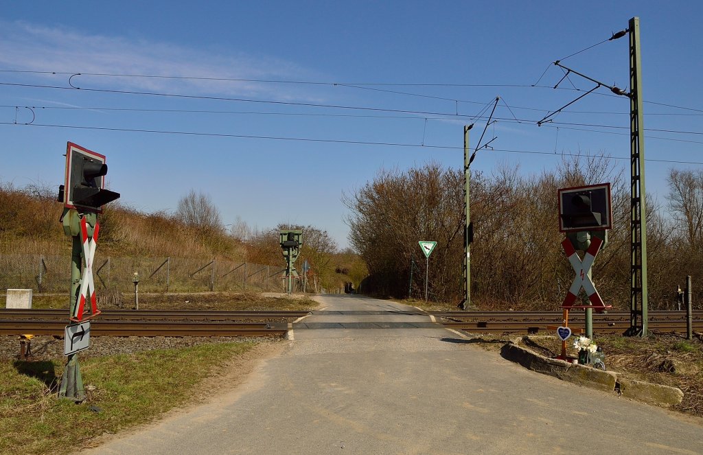 Bahnbergang Km 40,8 zwischen Kaarst - Meerbusch und Osterath gelegen und nur durch eine Blinklichtanlage gesichert. Das Leutwerk scheint defekt zu sein, zumindest am Tag der Fotoentstehung leutet es nicht bei Zugverkehr. An dieser Stelle bezahlte den Umstand das der bergang nicht durch einen Schrankenanlage gesichert ist eine damals 16 jhriger Motorrollerfahrer mit seinem Leben. Er stie mit einer RE zusammen, woran das Kreuz und die Lichter vor dem rechten Andreaskreuz erinnern. 7.4.2013