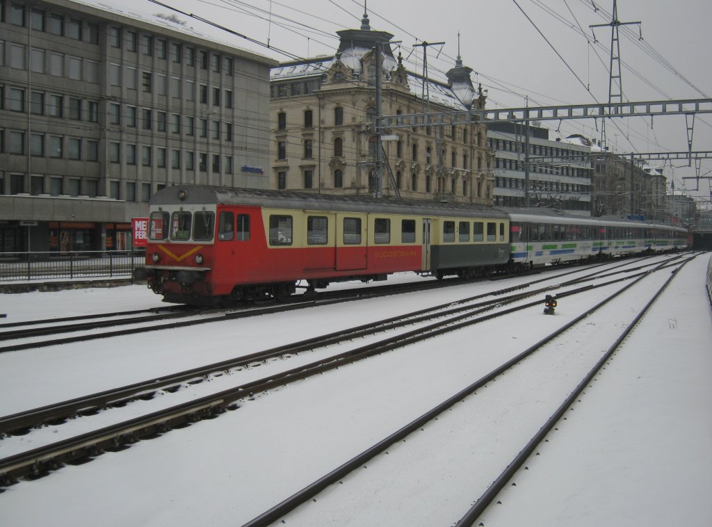 BDt 198, der letzte  alte  Steuerwgen, welcher nicht das Voralpendesign hat, mit dem IR VAE 2418 bei Einfahrt in St. Gallen. Am Zugschluss ist die Re 4/4 II 11135, 01.02.2012.