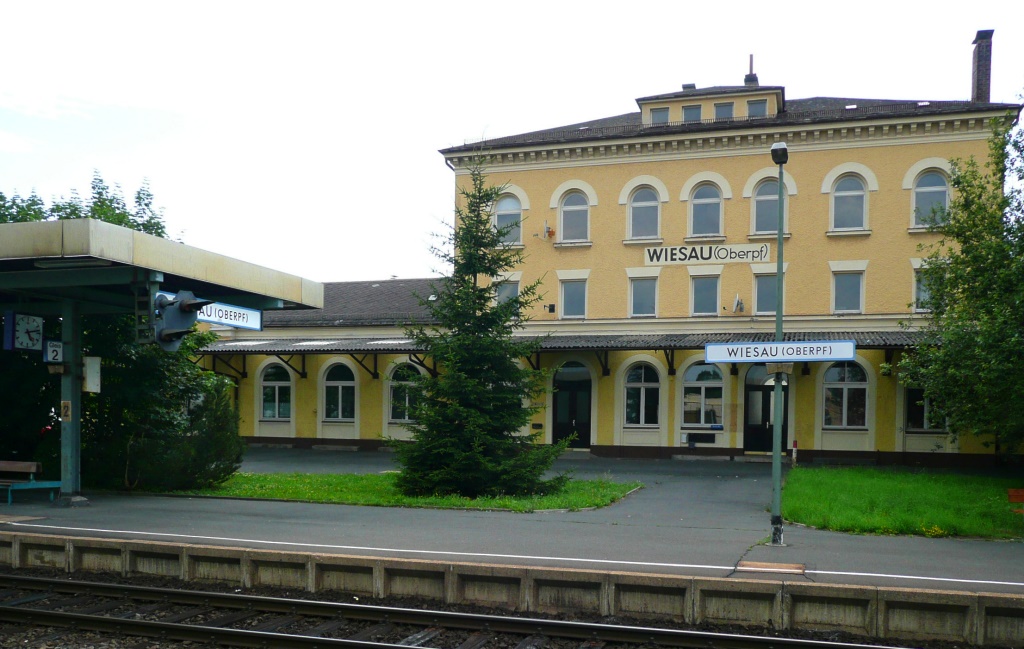 Beeindruckend ist das groe Empfangsgebude von Wiesau. Es zeugt von der Bedeutung, die der Bahnhof bis in die 1980er Jahre mit den zwei Nebenbahnen nach Tirschenreuth und Waldsassen hatte. Interessant auch das Vorsignal am Bahnsteigdach. (6.7.11)