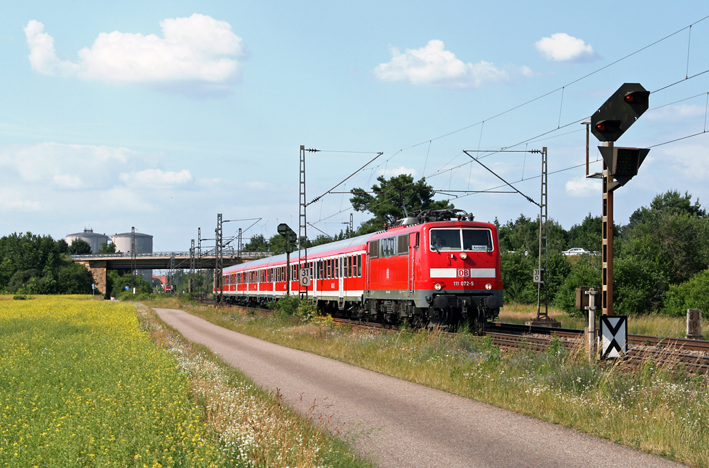 Bei angenehm sommerlichen Temperaturen befrdert die Ludwigshafener 111 072 die RB 18691 am 22. Juni 2010 von Mannheim nach Karlsruhe. Die Aufnahme entstand zwischen Waghusel und Wiesental.