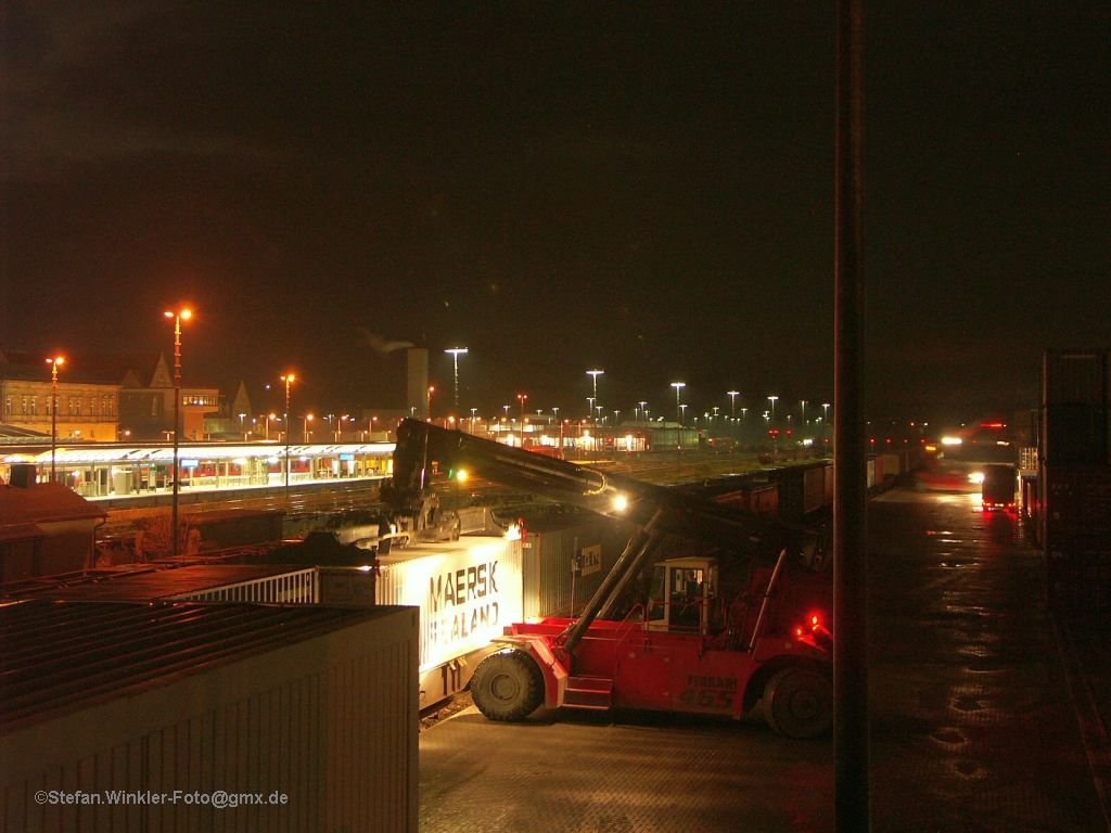 Bei Ankunft auf dem Luftsteg in Hof Hbf war am Containerbahnhof alles ruhig, die Lichter aus. Pl�tzlich gingen aber die Motoren und Lichter an, es wurde auch in der Dunkelheit gearbeitet. Evtl. war das vorher eine Schichtwechselpause. So konnte einer der Ferrari-Stapler beim Job in der Nacht fotografiert werden... 3.11.2009