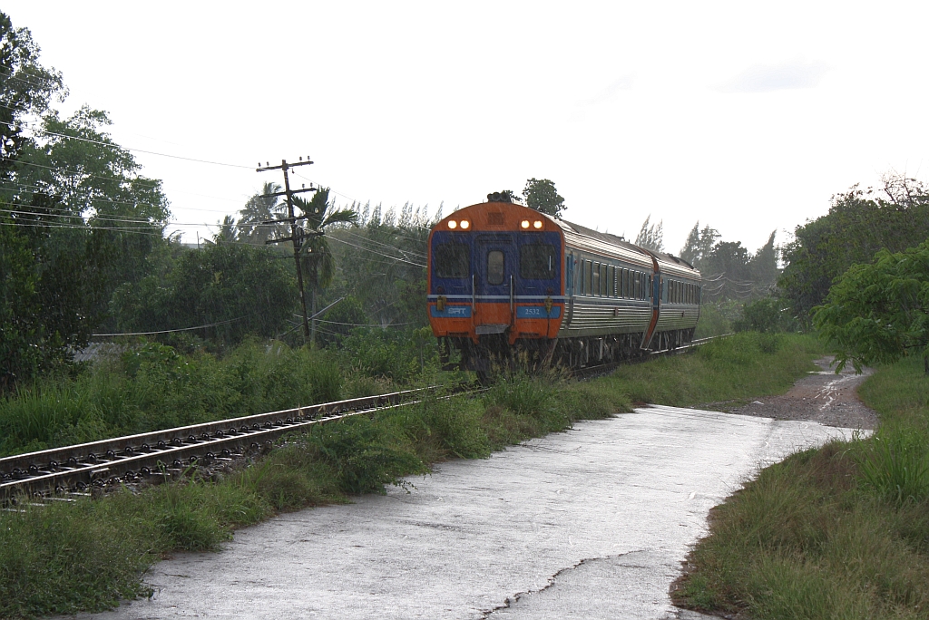 Bei einsetzendem Regen am 16.Mai 2013 nähert sich der APD.60 2532 als erstes Fahrzeug des SP EXP DRC 43 (Bangkok - Surat Thani) der 1953 errichtete Chulachomklao Bridge über den Tapi River. 

