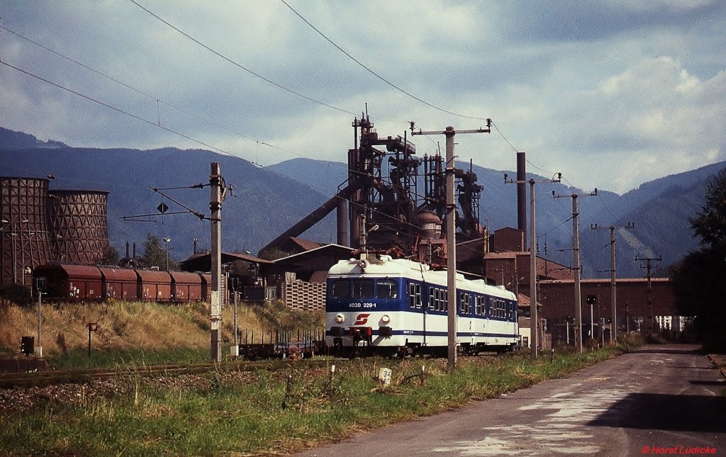 Bei Leoben-Donawitz ist 4030 229-1 im August 1997 nach Vordernberg unterwegs. Die Hochofenanlagen der VOEST-Stahlwerke bilden einen schönen Hintergrund.