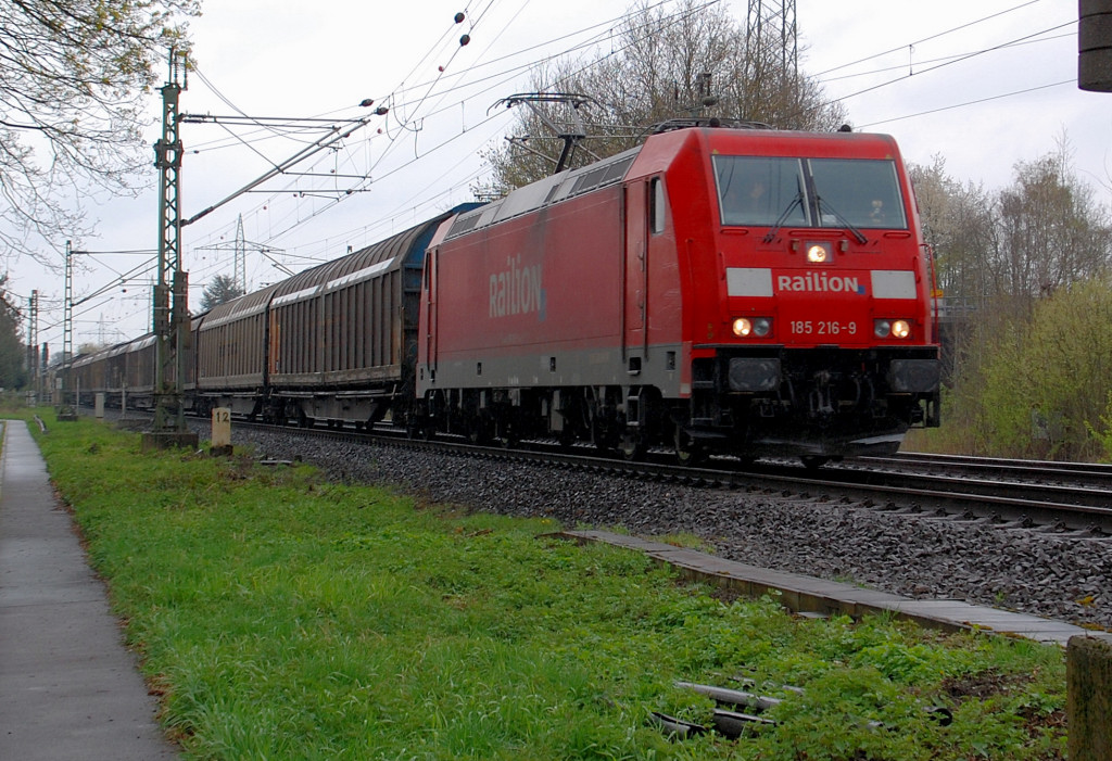 Bei usseligem Landregen kommt die 185 216-9 von Railion mit einem  Schiebewandwagenganzzug kurz vorm Bahnhof Lintorf aus Richtung Duisburg gefahren, an diesem Ostermontag den 9.April2012. Einen besonderen Gru� an den TF, der mich mit Hupe und Winken begr��te.