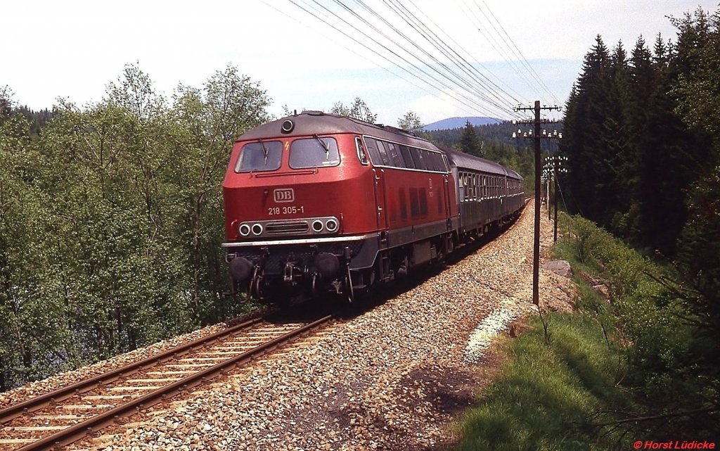 Bei Zwiesel ist 218 305-1 mit einem Personenzug von Bayrisch Eisenstein nach Plattling unterwegs (Mai 1979)