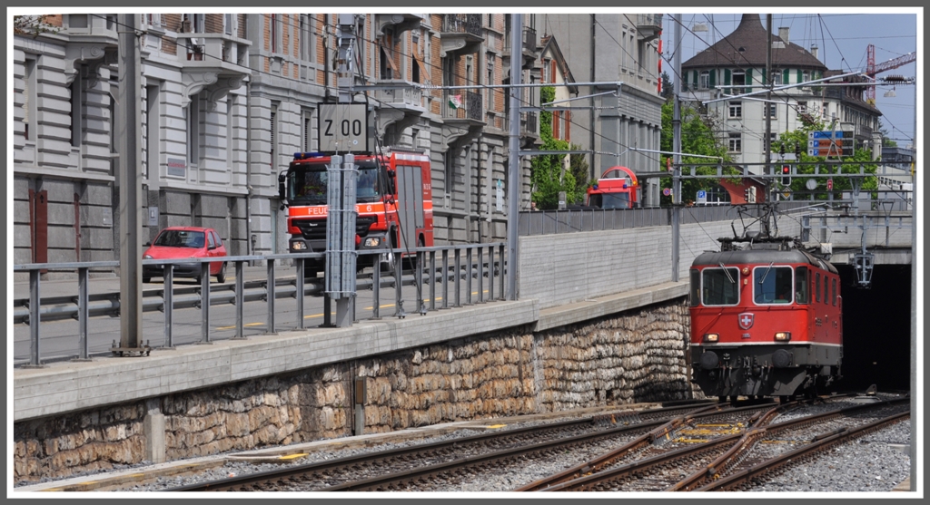 Beim Ausgang des Rosenbergtunnels in St.Gallen liefern sich Re 4/4 II 11115 und die Feuerwehr ein Wettrennen. (03.05.2011)
