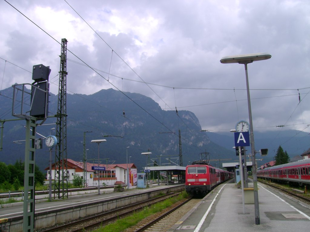 Blick auf den Bahnhof mit BR 111 und Zug nach Mittenwald.
Garmisch-Partenkirchen, 29.06.2009