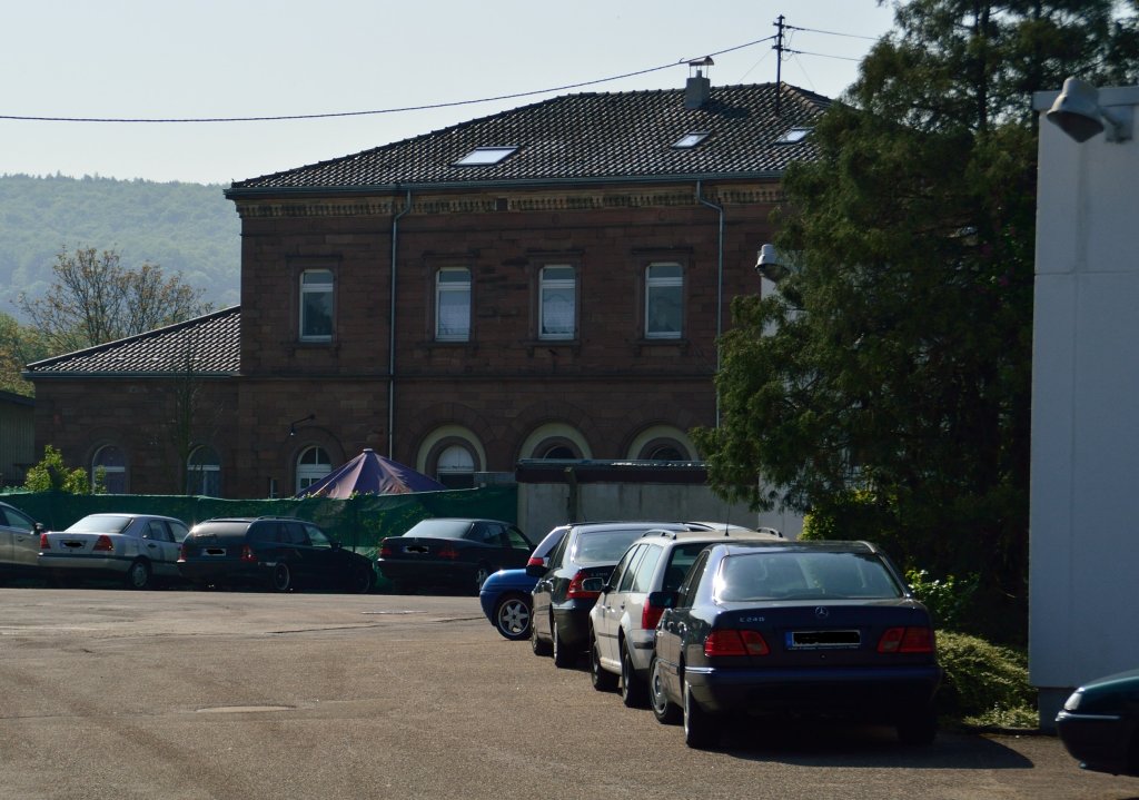 Blick auf das ehemalige Empfangsgebude des 1879 stillgelegten ersten Bahnhofs von Neckarelz. Heute befindet sich das Gebude auf dem Werksgelnde einer Eisengieerei. Das Bild entstand von ffentlichem Gelnde der Torhausstrae aus.
Es lag bis Mrz 1945 noch an den Gleisen der Schwarzbachtalbahn, die von Wrzburg ber Osterburken, Mosbach, Neckarelz, Obrigheim nach Meckesheim und weiter nach Neckargemnd fhrte.
1945 wurde die Neckarbrcke auf dem Rckzug vor den Allierten gesprengt und nach dem Krieg wurde diese nicht mehr aufgebaut.8.5.2013 