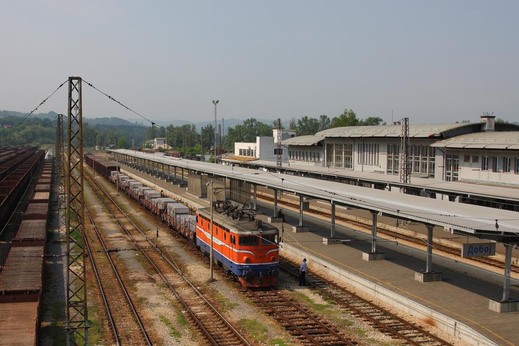 Blick auf das Hauptgebude und die Bahnsteige des Bahnhof Doboj
am 23.5.2011. Gerade fhrt ein Gterzug mit der E-Lok 441806 durch.