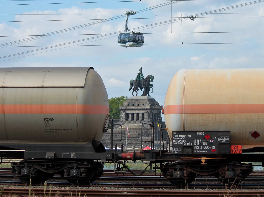 Blick von der B42 in Koblenz zwischen zwei Kesselwagen auf das auf der anderen Rheinseite auf dem Deutschen Eck stehende Reiterstandbild des Deutschen Kaisers Wilhelm I und der BuGa-Rheinseilbahn. (15.09.2011)
