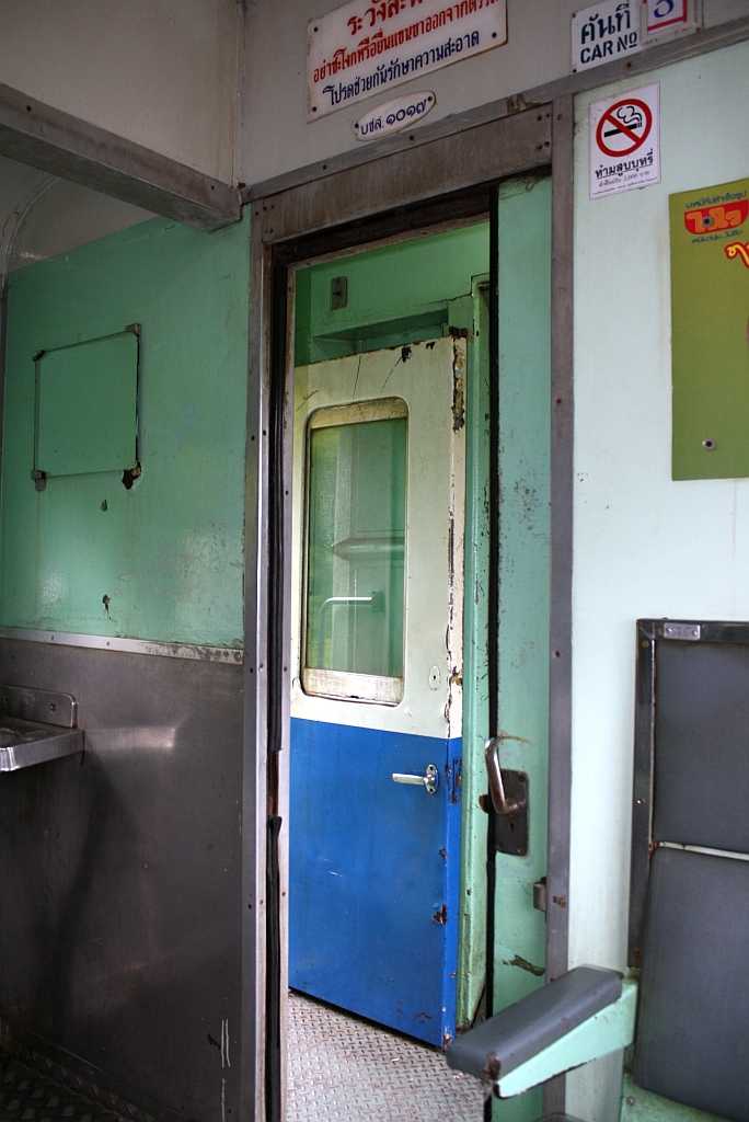 Blick von der ersten Sitzreihe auf den offenen Waschraum und in den Einstiegsraum des บชส.1017 (บชส. =BTC./Bogie Third Class Carriage). Selbstverständlich sind auch während der Fahrt alle Türen offen. Aufgenommen während der Fahrt mit dem EXP 51 zwischen den Bahnhöfen Den Chai und Pha Khan am 10.Jänner 2011. 

