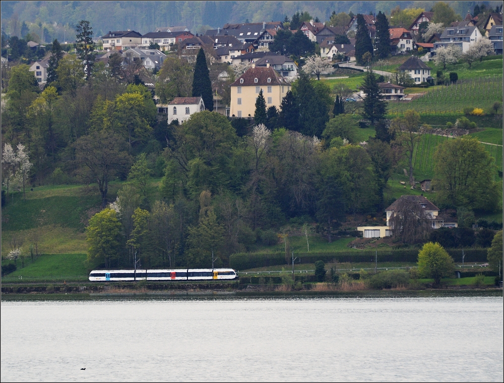 Blick ber die Grenze... auf Arenenberg im April 2013. Der GTW der Thurbo fhrt unterhalb des Napoleonschlsschens direkt am See entlang.