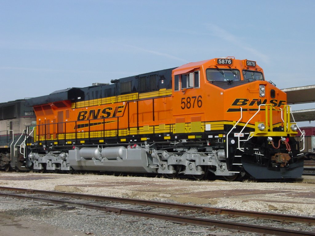 BNSF 5876 in fresh paint sits at the siding at the Burlington, Iowa depot coupled to Burlington Northern 9623. What a contrast in paint and cleanliness!