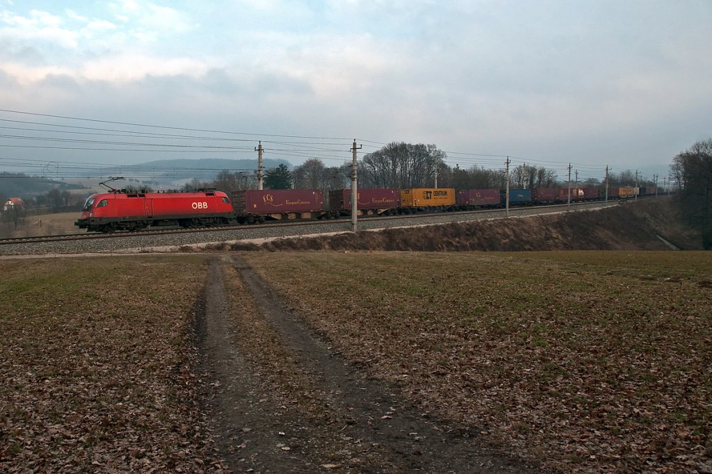 BR 1116 ist mit einem Containerganzzug Richtung Westen unterwegs. Die Aufnahme entstand am 17.02.2011 kurz nach dem Bahnhof in Bheimkirchen.