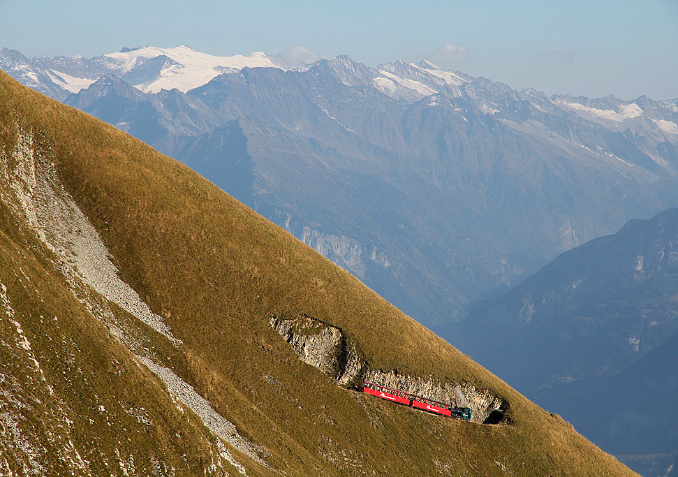 BRB-Dampfzug 3. Generation talwrts fahrend zwischen Schoneggtunnel II und I. Dahinter sichtbar das Haslital. Auf Wanderung nach Rothorn Kulm, 30. Sept. 2011, 16:34