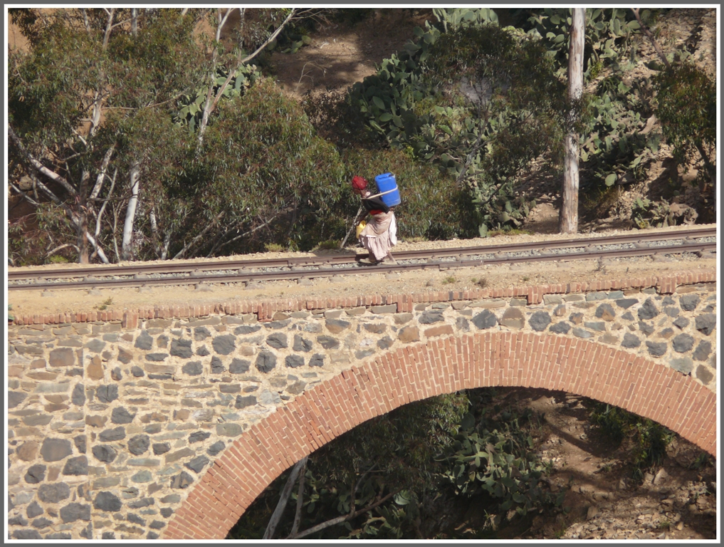 Brcken eignen sich bestens zum berqueren von tiefen Tlern. Zug hin oder her, das hat sich auch diese Frau gedacht, die mhsam einen Kanister Trinkwasser nach Hause schleppt. (30.01.2012)