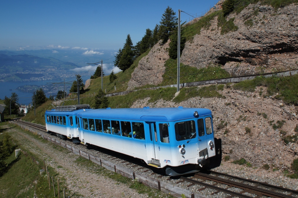 Bt 24 und BDhe 2/4 14 fahren am 17.8.12 als Regio 135 von Rigi Staffel Richtung Rigi Kulm. Im Hintergrund ist der Vierwaldstttersee zu sehen.