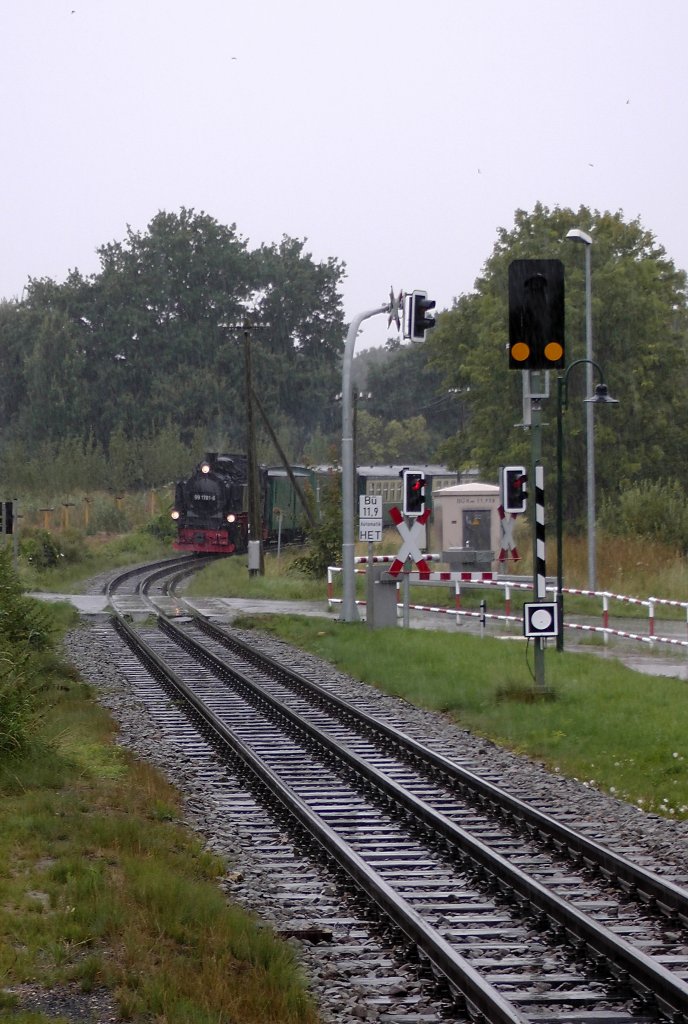 B 11,9. Die Automatischranke ist geschlossen und 99 1781 - 6 wird in wenigen Augenblicken passieren, Starkregen am 30.08.2012 gegen 13.15 Uhr
Die Gleise queren hier die Frst-Malte-Allee.