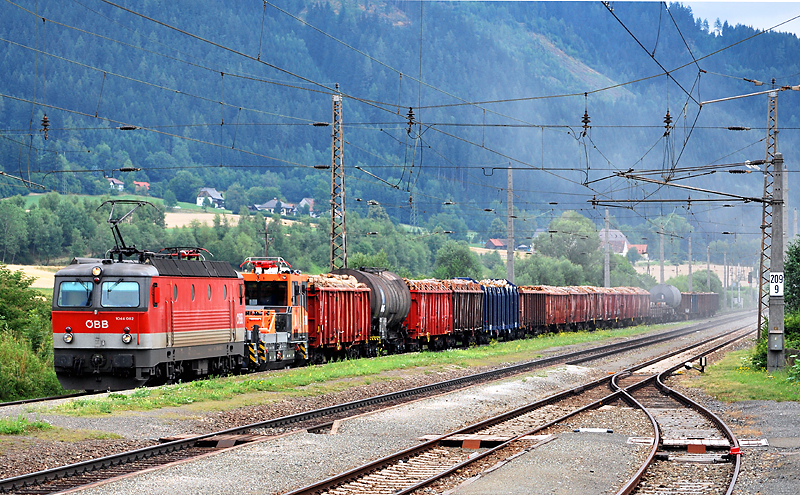 Bunt gemischter Gterzug samt Kran hinter der 1044 062 am 20.7.2010 bei der Durchfahrt in Kraubath/Mur.
