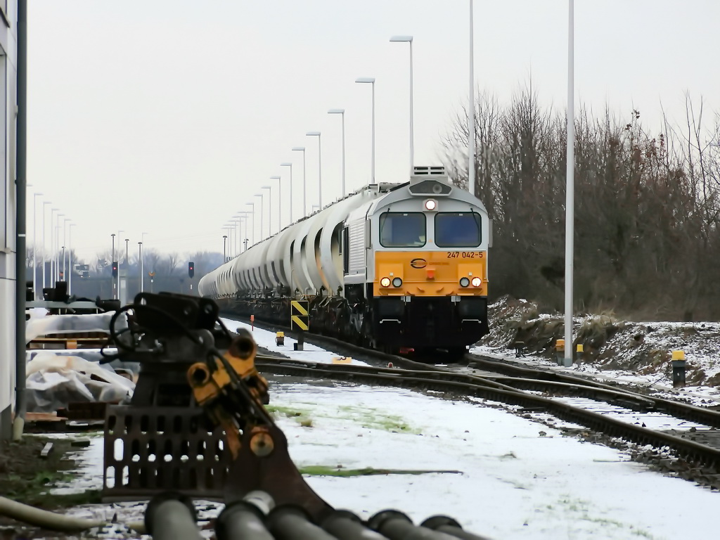 CARGO RAIL 247 042-5 mit einem Ganzzug  Staubgutwagen im Bereich der Anschlussbahn fr das Zementwerk der CEMEX in Rdersdorf bei Berlin, gesehen am 04. Dezember 2012 durch einen Blick ber den Zaun.