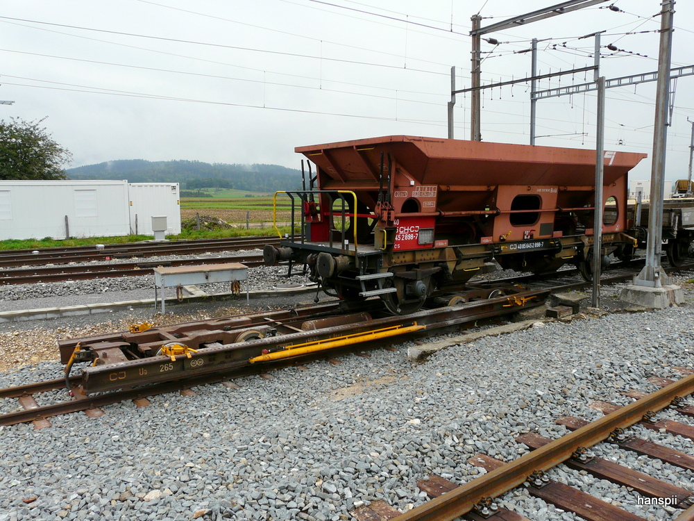 CJ - Rollschemmel Ua 265 mit dem Schotterwagen Fcs 40 85 645 2 898-7 im Bahnhof Glovelier am 30.09.2012