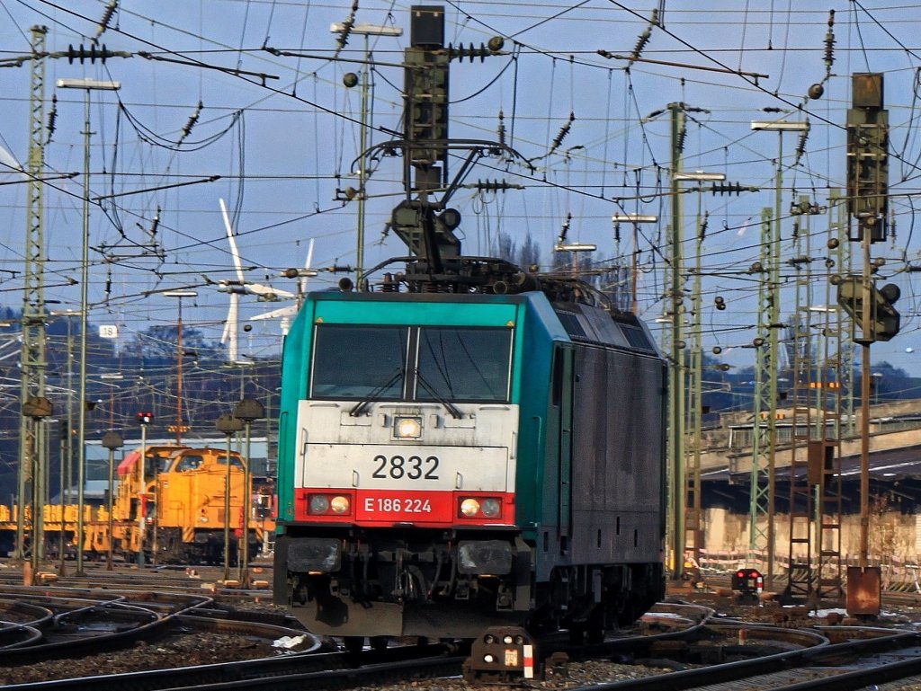 Cobra 186 224 (2832) rangiert am 11.12.2012 durch einen Wald von Masten, Signalen und Fahrdrahtanlagen in Aachen West. Im Hintergrund steht 203 304-1 der DGB mit einem leeren Langschienenzug und wartet auf Abfahrt Richtung Kln.