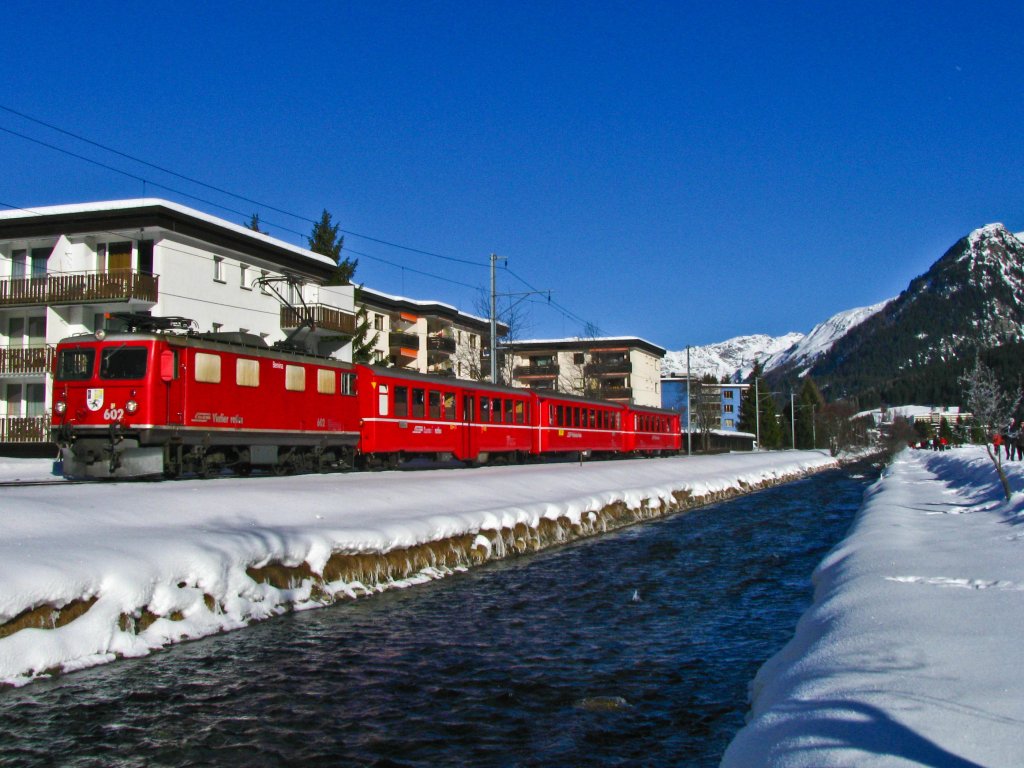Dafr stehe ich am Neujahrsmorgen um 5 Uhr auf: Um die Skizge Klosters-Davos, gezogen von den alten Vierachsern Ge 4/4 I zu fotografieren. Lok 602 ist hier gerade mit dem R 827 (Klosters Dorf-Davos Platz) zwischen den beiden Davoser  Hauptbahnhfen  unterwegs. Nebenan fliesst die Landwasser, deren Namen vom berhmten Viadukt her bekannt sein drfte... (1.Januar 2011)