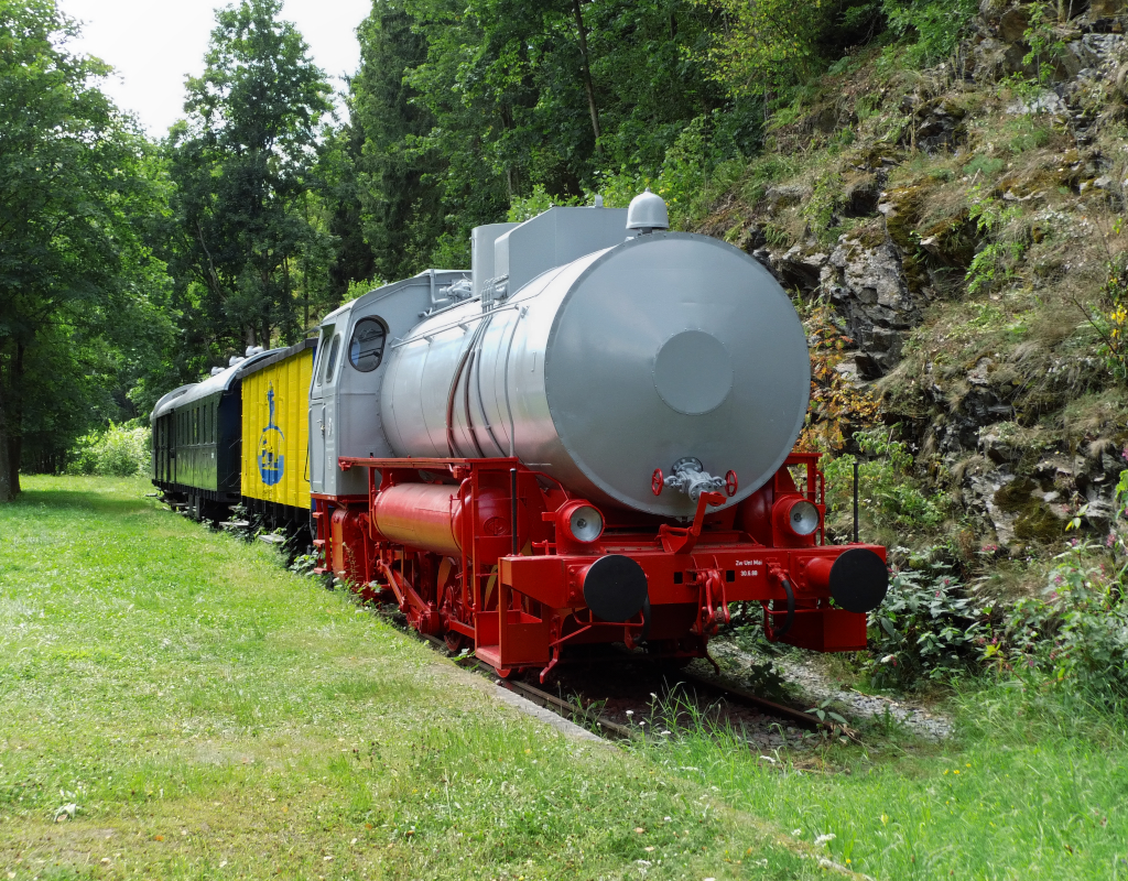 Dampfspeicherlok im Hllental. Nein, wir waren nicht im Schwarzwald,sondern im Hllental das im Grenzgebiet zwischen Oberfranken und Thringen liegt. Durch dieses Hllental verlief eine Bahnlinie.

Die Lok wurde von VEB  Karl Marx  Babelsberg im Jahr 1969 gebaut und war in Blankenstein bei der Zellstoff- und Papierfabrik im Einsatz.

Bis April 1945 fuhren Zge durch das frnkische Hllental. Die rund 6 Kilometer durch das Hllental gehrten zur Strecke Triptis - Ziegenrck - Unterlemnitz (Thringische Oberlandbahn) - Lobenstein - Blankenstein - Marxgrn.

Zwischen Blankenstein (Thringen) und Marxgrn (Bayern) entstand nach dem II Weltkrieg die Deutsch - Deutsche Grenze.

Der illustre Zug steht heute im ehemaligen Bahnhof Lichtenberg (Ofr). Zweihundert Meter nach rechts befindet sich heute die Grenze Bayern/Thringen)

Zwischen Blankenstein und Marxgrn liegen keine Gleise mehr.
Die Strecke ist nicht entwidmet und es laufen Bestrebungen wieder die Lcke zwischen Marxgrn und Blankenstein zu schlieen. 13.08.2012


