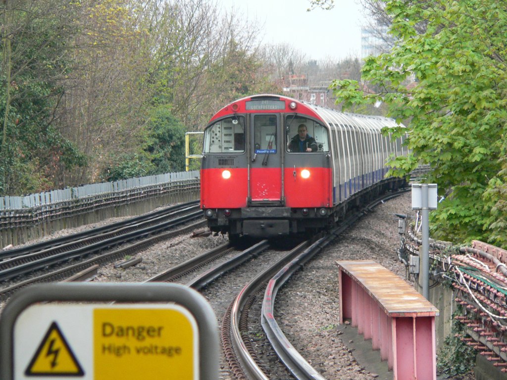 Danger - High Voltage. Eines von vielen Hinweisschildern in der Londoner Tube. Hier wird man u.a. darauf hingewiesen, dass das Offenhalten der T�ren gef�hrlich ist, Zeitungen die T�ren verklemmen k�nnen, die F��e nicht auf den Stuhl geh�ren (so ein Schild h�tte ich gerne mal in Berlin) und man immer eine g�ltige Fahrkarte haben soll. Die High Voltage sind �brigens 650 Volt Gleichspannung, die �ber zwei Stromschienen (eine links oder rechts neben der Schiene, eine zwischen den Schienen) an den Zug weitergegeben werden. Piccadilly Line, London, 9.4.2012