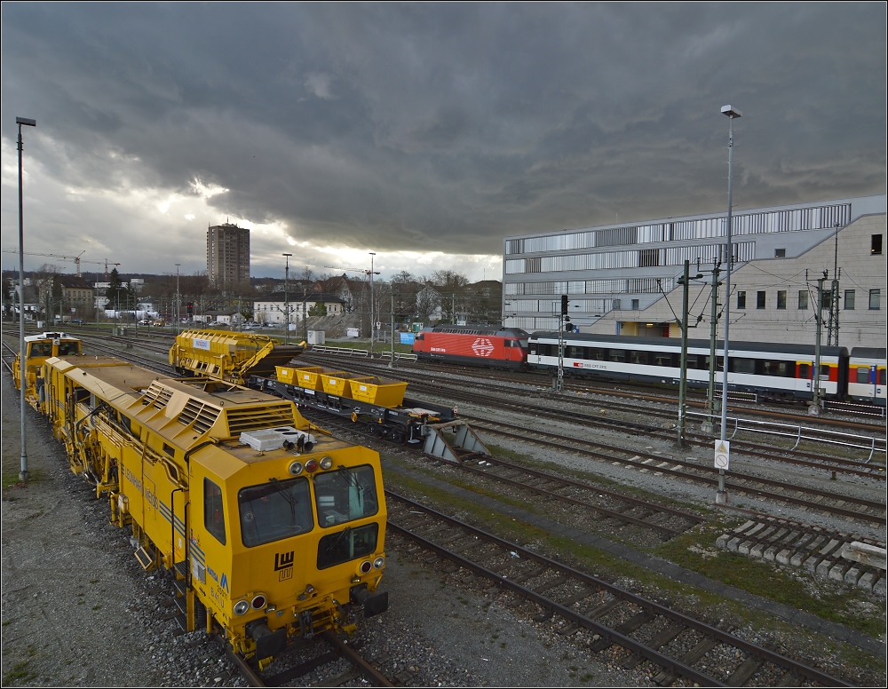 Das erste Gewitter 2013 droht grenzberschreitend... Im Vordergrund stehen Arbeitsgerte von Leonhard Weiss bereit fr die weiteren Arbeiten zur Gleiserneuerung in Konstanz, whrend im Hintergrund eine 460 mit ihren Interregio Richtung Biel startet. April 2013.