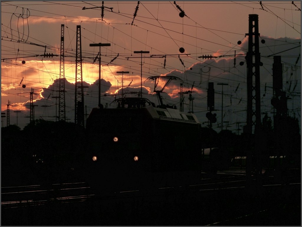 Das Motto zum Bild : The sun goes down. Der Abend bricht herein ber den Aachener
Westbahnhof. Eine E Lok rangiert im Gleisvorfeld,whrend sich dicke Wolken am Himmel trmen.Aufnahme vom August 2012.