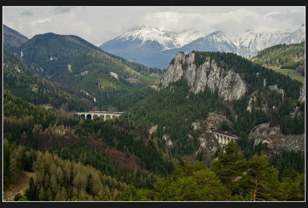 Das Panorama vom 20-Schilling-Blick aus: Gterzug Richtung Gloggnitz in aqudater Lnge mit 1144 als Zug- und 1142 als Schublok. Zumal fast mit Theaterbeleuchtung, Breitenstein/Wolfsbergkogel, 17.4.2012