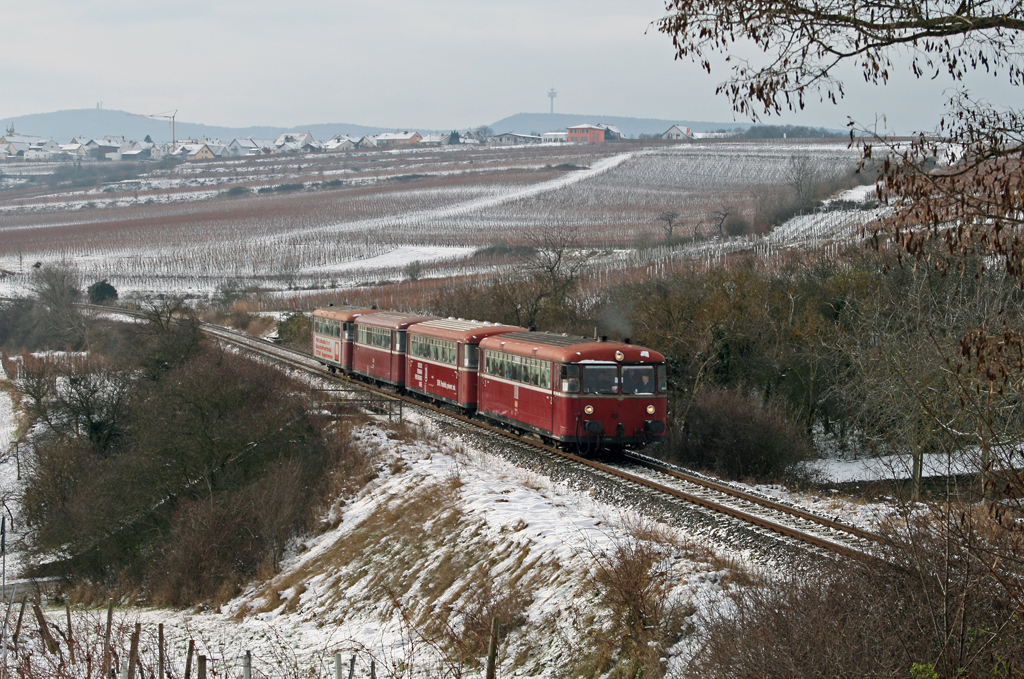 Das zweite Mal konnte die Schienenbusgarnitur der Pfalzbahn am 20. Dezember 2009 bei Herxheim am Berg fotografiert werden. Da mittlerweile ein Motorwagen nicht mehr so richtig wollte, musste sich der fhrende 798 622 mchtig ins Zeug legen, um die Steigung nach Grnstadt zu erklimmen, was hier am Dackenheimer Berg zu einem herrlichen Sound fhrte :-)
