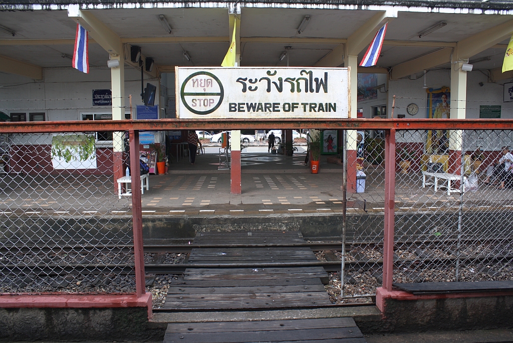 Dass man auf den Zug achten soll, ist natuerlich ein ernst zunehmender Hinweis. Allerdings sollte man ab einer Koerpergroesse von 185cm auch auf den Kopf achten. Hinweisschild am Ubergang vom Hausbahnsteig zum mittelbahnsteig im Bf. Surat Thani am 17.Mai 2013. 

