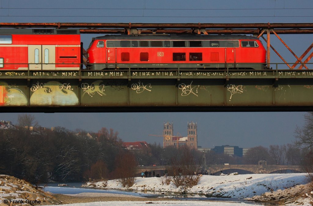 DB 218 466 schiebt Sdostbayernbahn RE 27056 Mhldorf - Mnchen, KBS 940 Mhldorf - Mnchen, fotografiert auf der Isarbrcke zwischen Mnchen Ost und Mnchen Hbf. am 14.02.2013 --> im Hintergrund die Wittelsbacherbrcke und die katholische Kirche St. Maximilian im Mnchener Glockenbachviertel