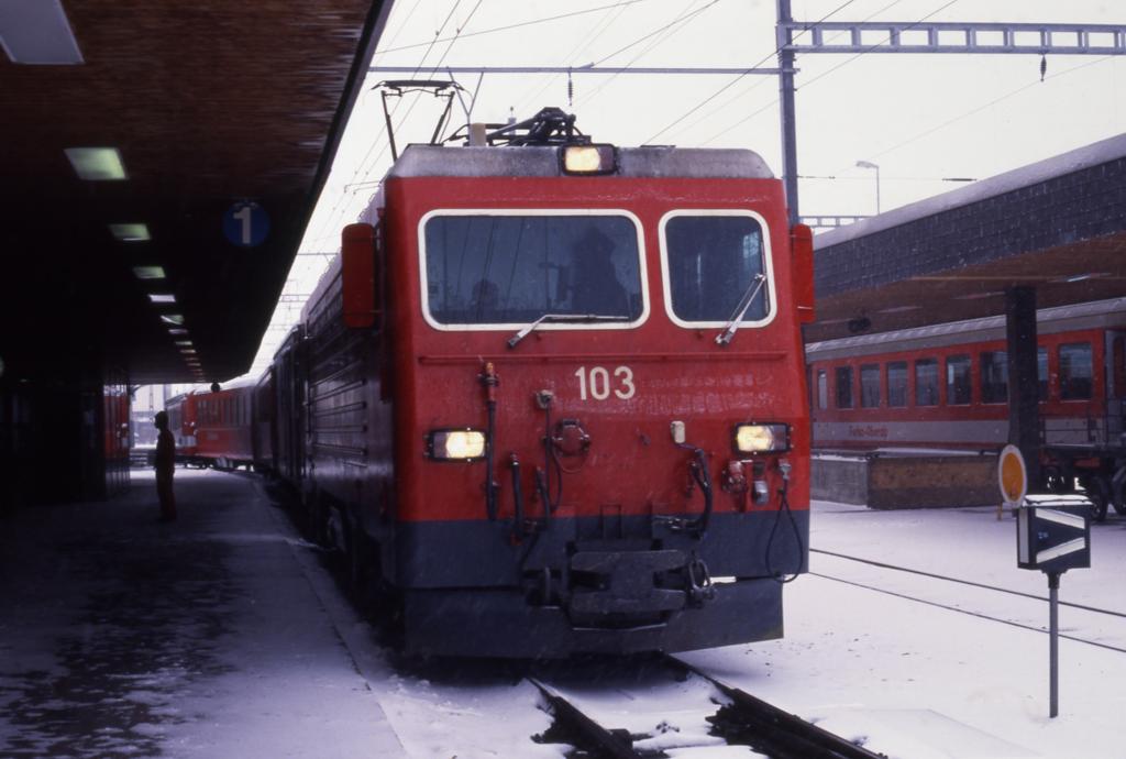 De 103 im spten Winter am 26.31990 um 8.30 Uhr im Bahnhof Andermatt
vor einem Personenzug nach Brig.