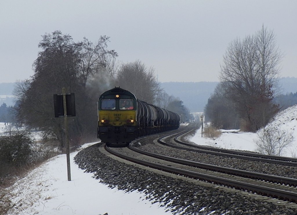 DE 67 der ASCENDOS hat mit den Kesselwagen die Steigung zwischen Bad Schussenried und Wattenweiler fast geschafft. Der Kesselwagenzug wird auf der Fahrt von Aichstetten nach Ulm in wenigen Augenblicken die Wasserscheide zwischen Donau und Rhein passieren (Wattenweiler, 21.02.2013).