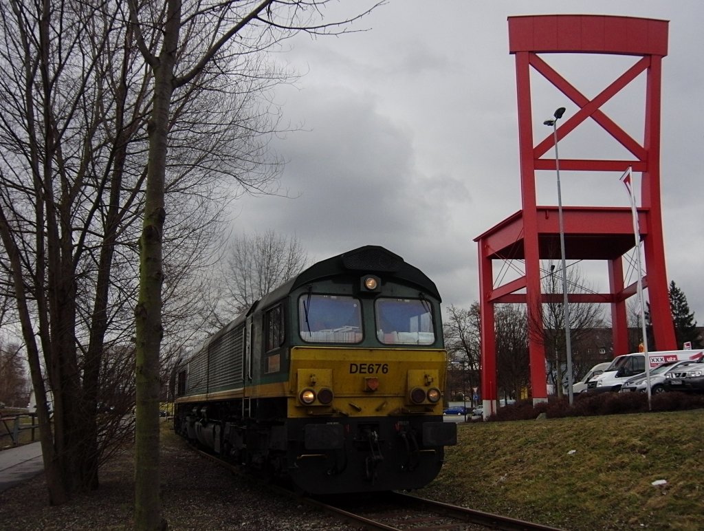 DE676 der ASCENDOS fhrt am 08.03.2012 mit befllten Kesselwagen von Friedrichshafen Gbf ins Industriegebiet Friedrichshafen, um einen Heizlhndler zu beliefern. Dabei fhrt die Fahrt auch am groen Stuhl eines Mbelhauses vorbei.