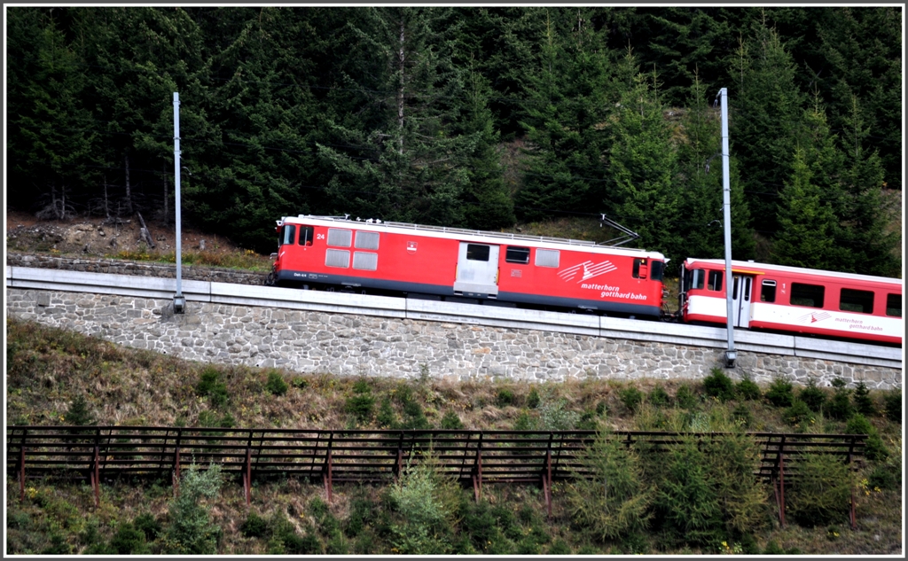 Deh 4/4 93 vor einem ABt Steuerwagen. Die Lawinenverbauungen dienen dem Schutz der Strasse unterhalb der Bahnlinie bei Tschamut-Selva. (25.09.2012)