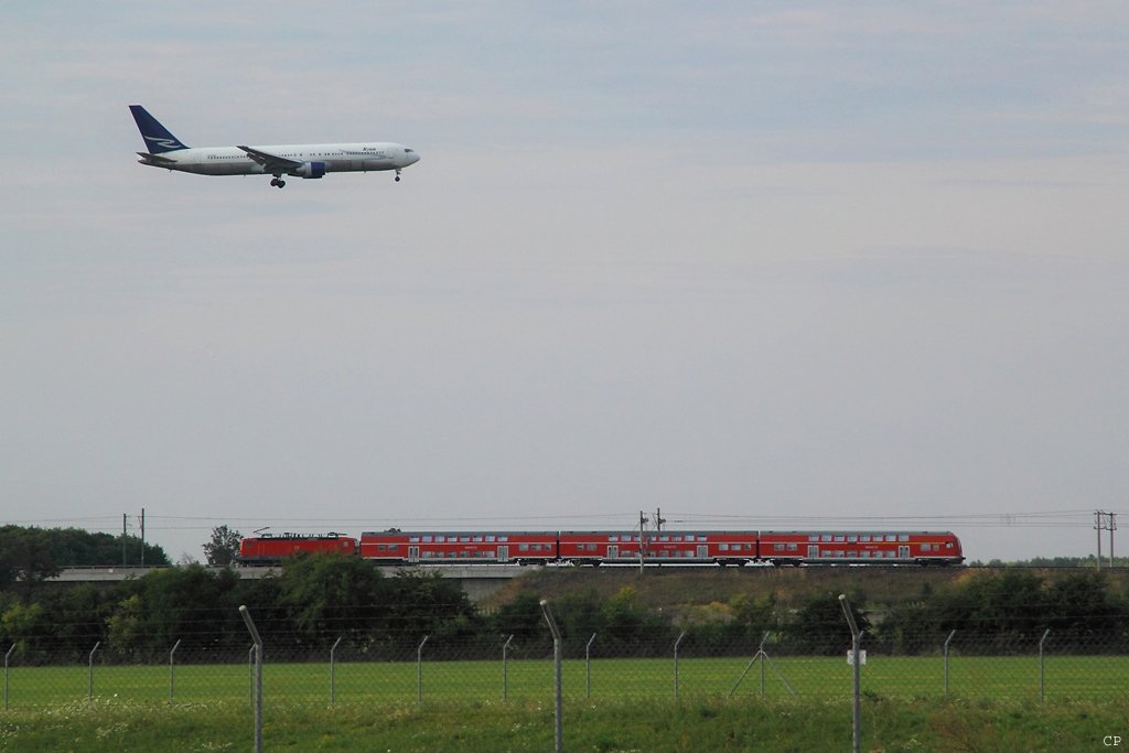 Der von einer 143 geschobene RE 26031 und eine 767 von Ryan International Airlines am 9.8.2009 im Anflug auf den Flughafen Leipzig/Halle. [berarbeitete 1024x-Version]