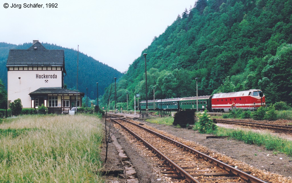 Der Bahnhof Hockeroda liegt etwa in der Mitte zwischen Probstzella und Saatfeld. Die gleichnamige Ortschaft hat nur etwa 100 Einwohner. Bedeutung erhlt er nur durch die abzweigende Strecke nach Lobenstein. Im Juni 92 prsentierte er sich noch im „Reichsbahnzustand“, auf Geis 3 wartet 219 059 mit einem Personenzug auf die Weiterfahrt nach Saalfeld.
