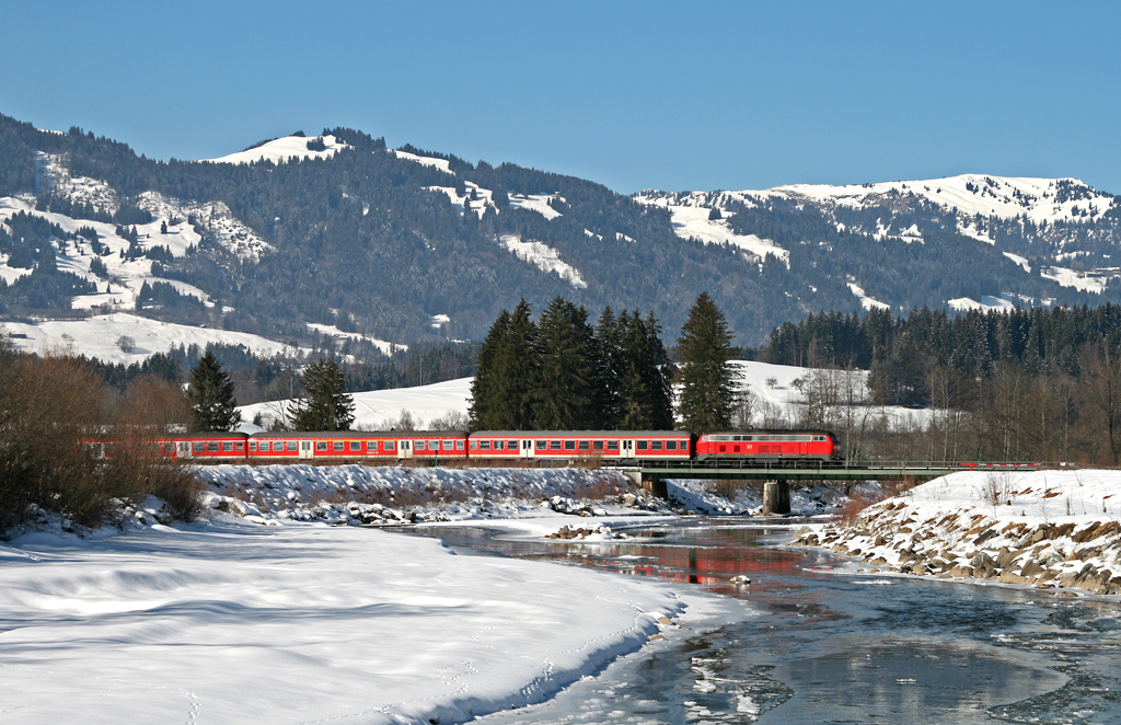 Der Baureihe 218 sind auf der Nebenbahn zwischen Immenstadt und Oberstdorf nur noch wenige Leistungen geblieben – die DB wickelt den Groteil der Fahrten mittlerweile mit Triebwagen der Baureihe 612 ab. Eine der letzten lokbespannten Regionalzge ist die RB 32912 von Oberstdorf nach Kempten (Allgu), mit der die Kemptener 218 458 am herrlichen 16. Februar 2010 bei Fischen im Allgu die Iller berquert.