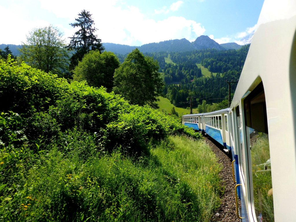 Der Berner Oberland Bahn-Triebwagen 309 auf der Fahrt zwischen Hausberg und Kreuzeck. Davor die beiden Steuerwagen 211 und 213 der einstigen Solothurn Zollikofen Bern-Bahn. 17.Juni 2012. 