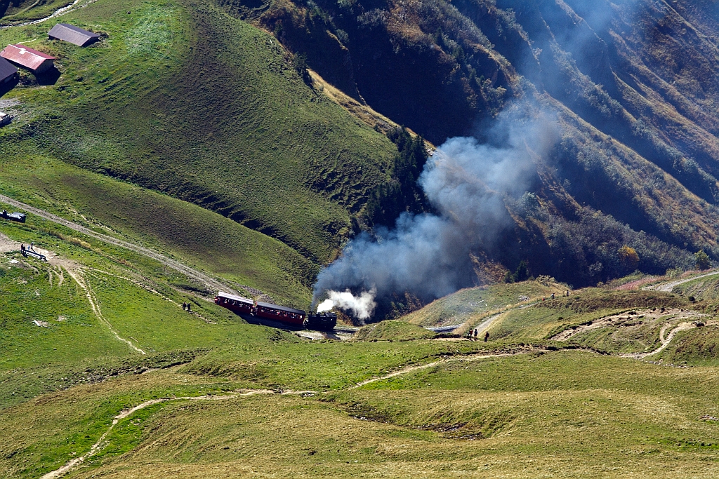 Der Dampfer steigt fast mhelos aber rauchend den Berg hinauf. Die Kohle befeuerte BRB 6 fhrt am 01.10.2011 zum Brienzer Rothorn hinauf, hier kurz vor dem Kreuzungsstelle Oberstafel (1828 m . M.). Ganz links ist eine vorfahrende l gefeuerte Lok zusehen, die nicht so raucht.