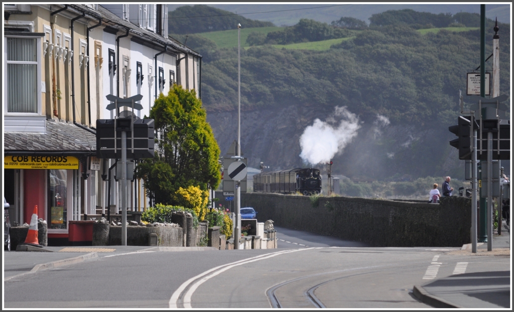 Der Dampfzug der Ffestiniog Railway nhert sich der Endstation Porthmadog und berquert den Damm Cob, der das Meer von den dahinterliegenden Marschwiesen trennt. Das Geleise im Vordergrund gehrt der neuen Verbindung zur Welsh Highland Railway, die hier kurz Streetrunning betreibt. (04.09.2012)