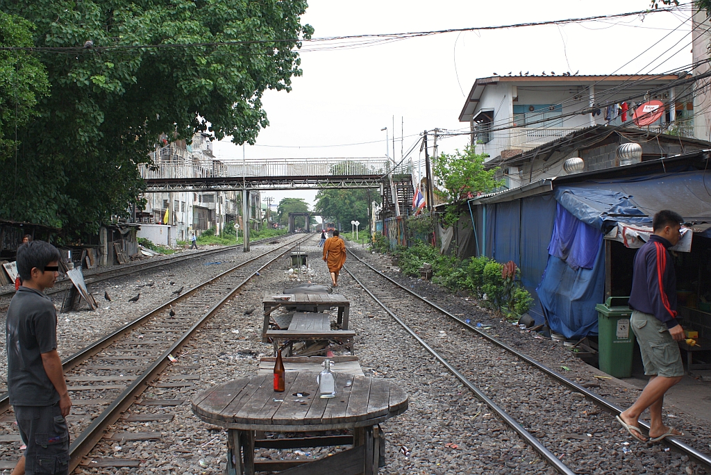 Der Einfahrtsbereich des Bf. Hua Lamphong gleicht zeitweise einer Fugngerzone mit Gastgarten. Man beachte die Tischplatte: der Seitenteil einer Kabeltrommel. Bild vom 18.Mrz 2011.