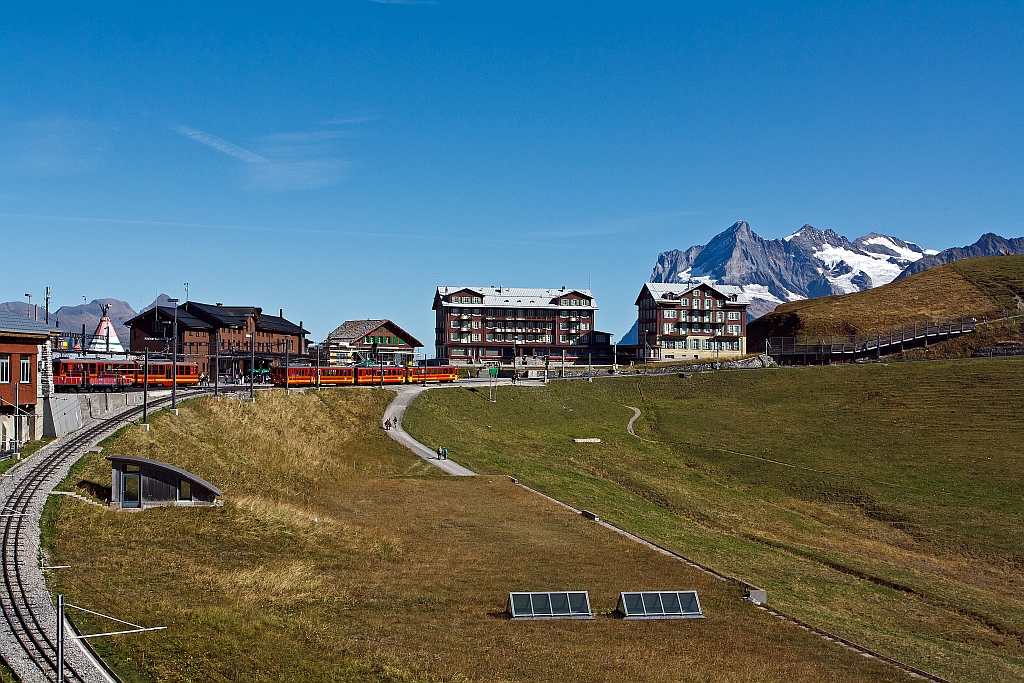 Der erste Blick zum Bahnhof Kleine Scheidegg, aus dem Zug der WAB vor der Einfahrt am 02.10.2011. Bei dem traumhaften Wetter. Links der Bahnhof, davor Triebwagen der Jungfraubahn, Bildmitte das Hotel Bellevue des Alpes, dahinter das Wetterhorn.