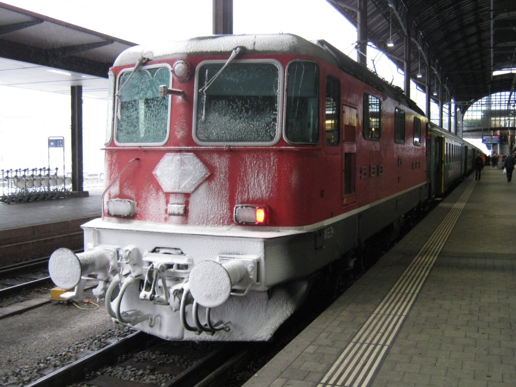 Der erste Schnee im Flachland! Re 4/4 II 11133 mit Ersatzkomposition als IR 2076 im Bahnhof Basel, 27.11.2010.