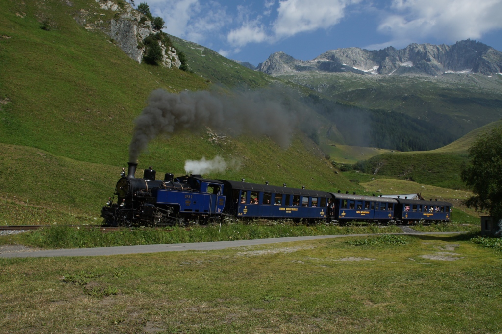 Der erste Zug des Tages verlsst am 27.7.12 Realp in Richtung Furkapass. Gezogen wird er von der HG 3/4 1. 
